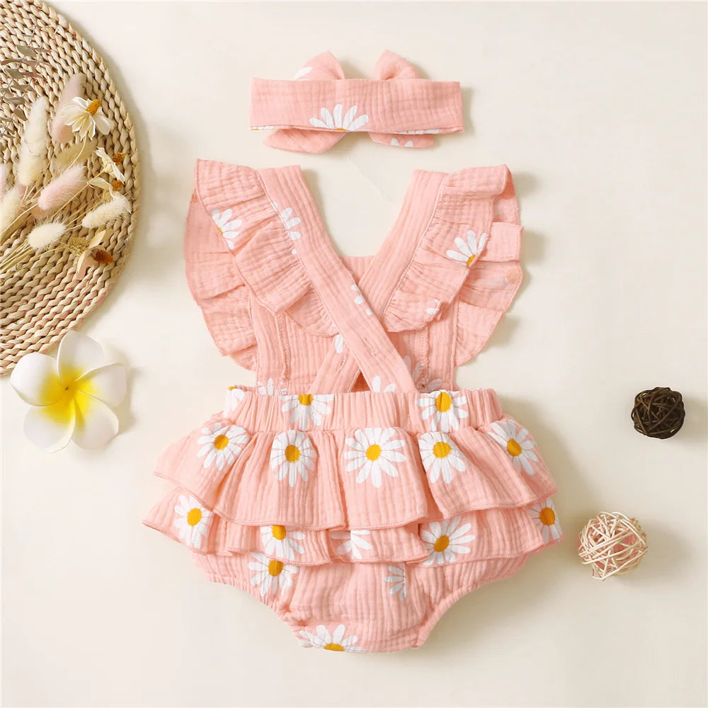 Pink baby romper with floral design and matching headband on a light background