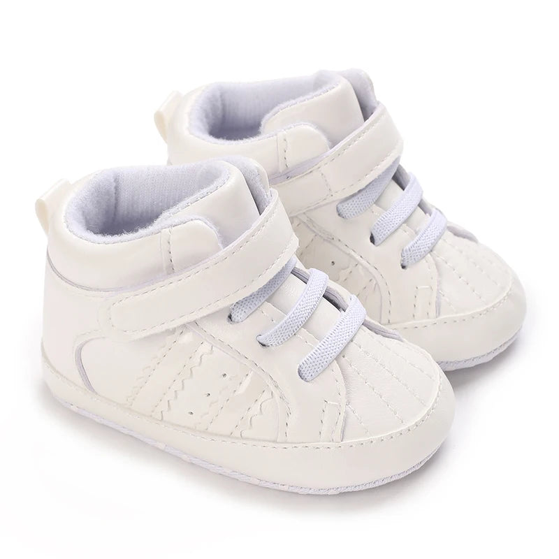 White baby sneakers with gray soles on a white background