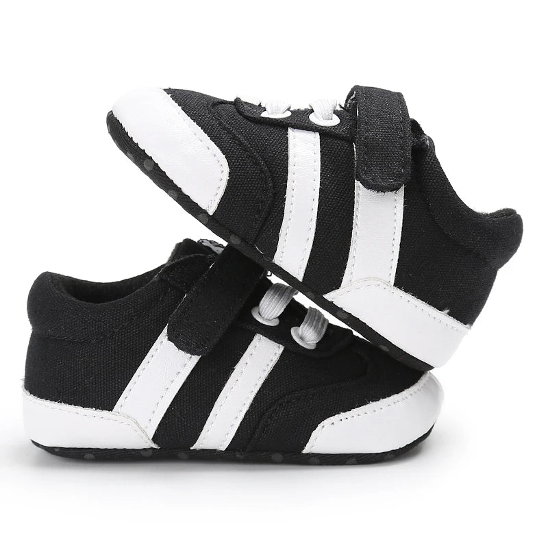 Black and white baby sneakers with velcro straps on a white background