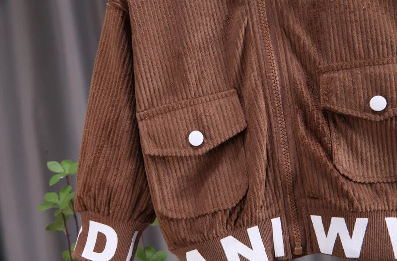 Brown corduroy jacket with white buttons and visible branding on a gray background