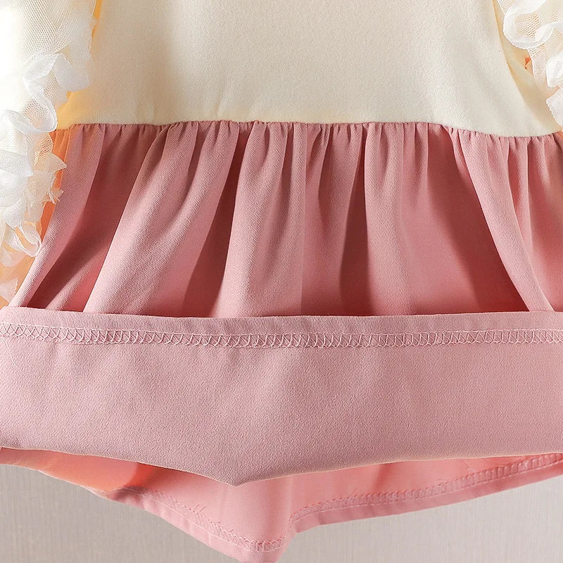 Close-up of a pink skirt with a white top on a neutral background