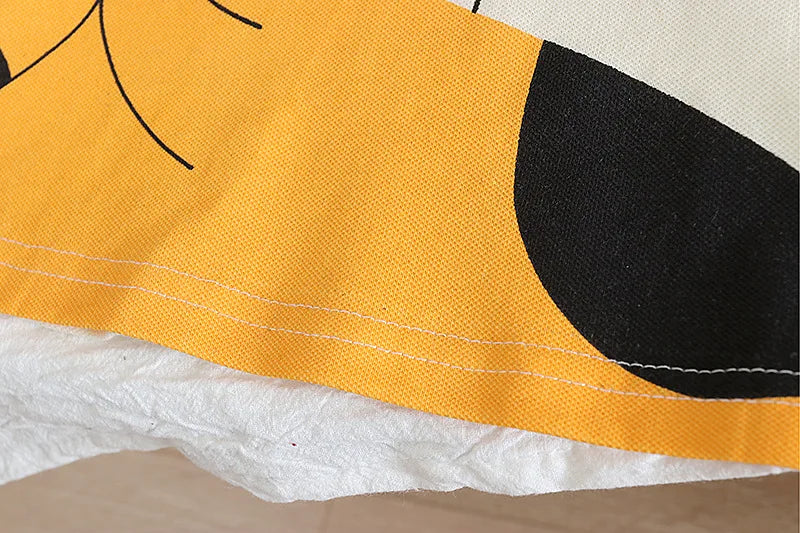 Close-up of a yellow and black shoe with white sole on a beige background