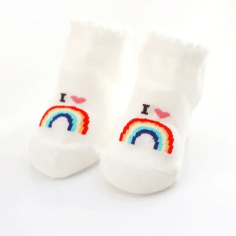 Pair of socks with rainbow and heart designs on a white background