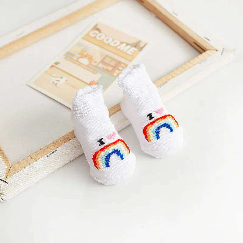 White socks with rainbow designs on a light wooden surface