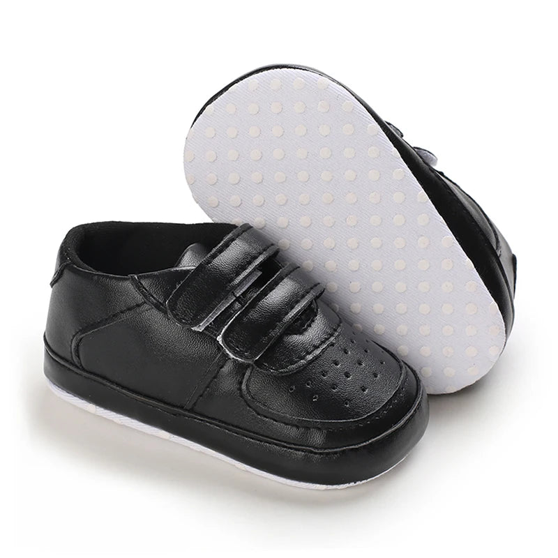 Black leather shoe with velcro straps on a white background