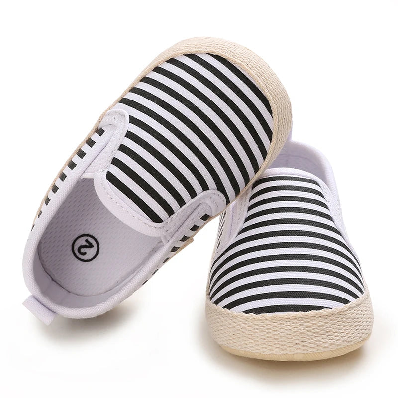 Pair of black and white striped shoes with a brand logo on a white background