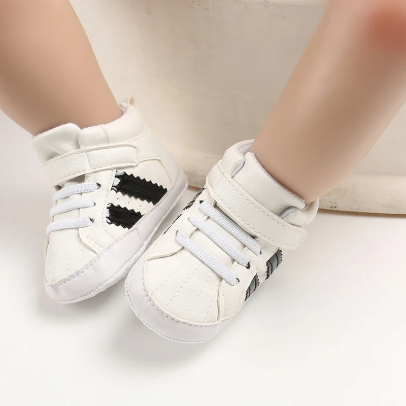 White sneakers with black heart designs on a light background