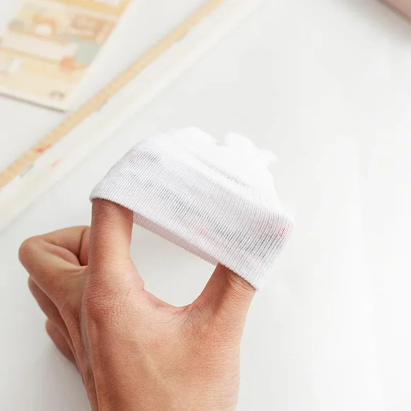 Close-up of a hand holding a white cylindrical object with a textured surface.