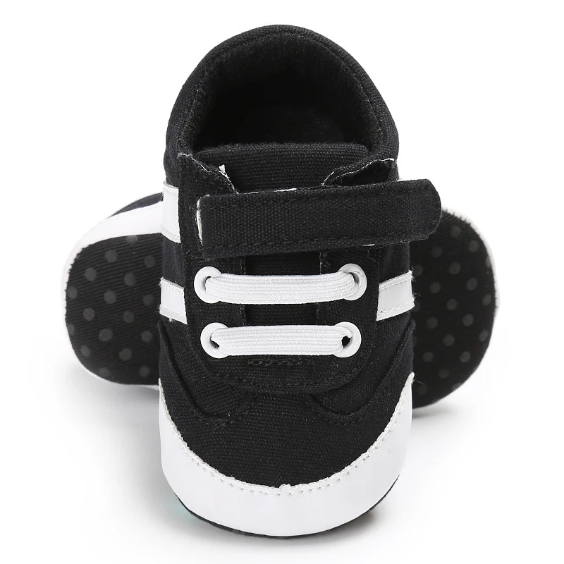 Black and white baby shoes with velcro straps on a white background