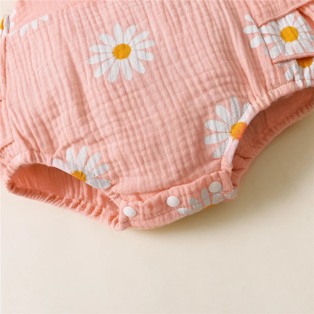 Pink baby bloomers with daisy flower patterns on a beige background