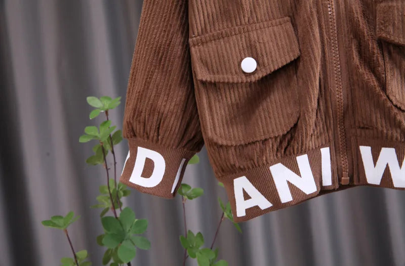 Brown corduroy jacket with 'DANIEL' branding on a gray background