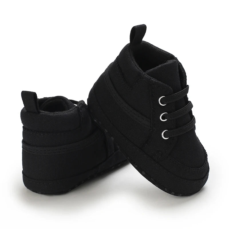 Pair of black baby shoes on a white background