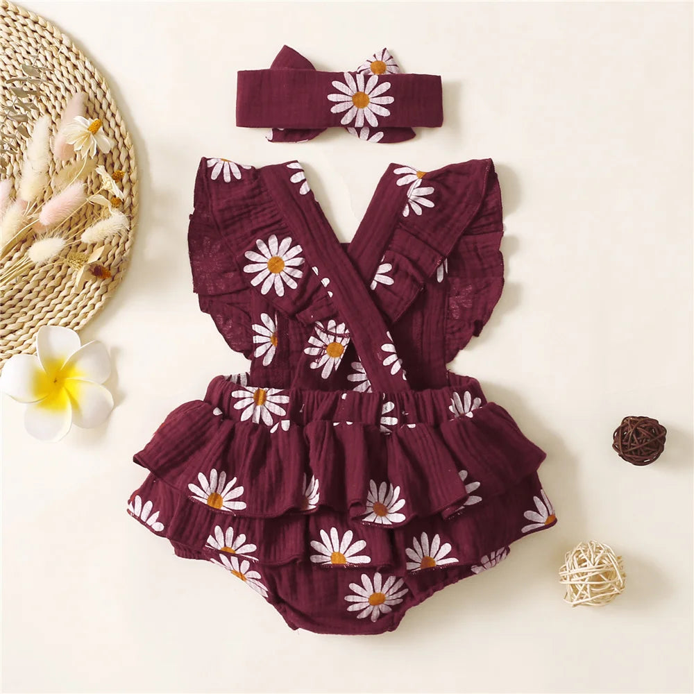 Baby romper with floral pattern and matching headband on a light background