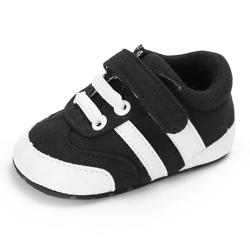 Black and white baby shoe with velcro straps on a white background