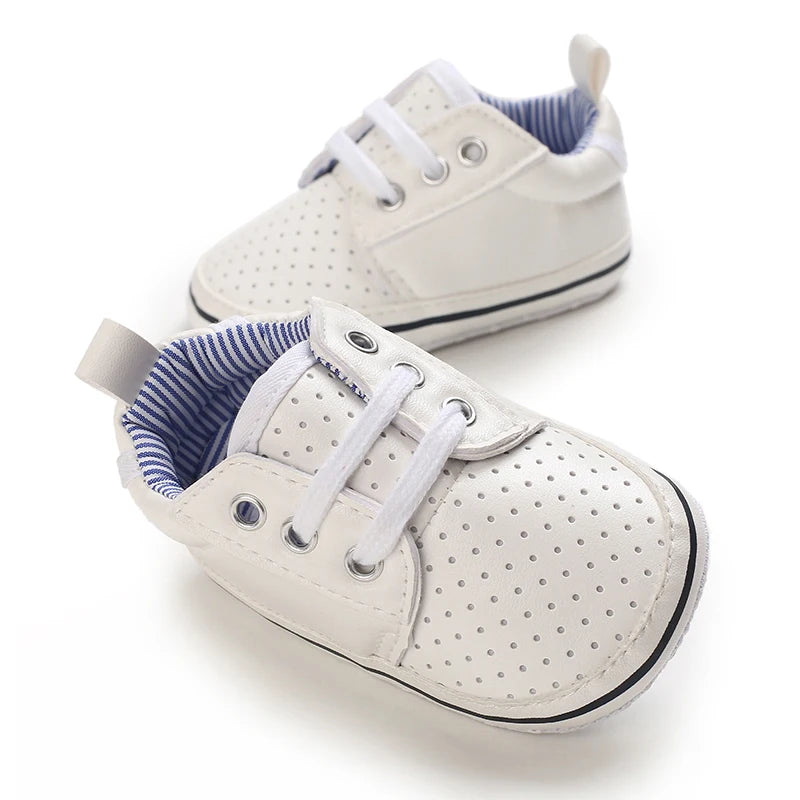 White baby sneakers with blue lining on a white background