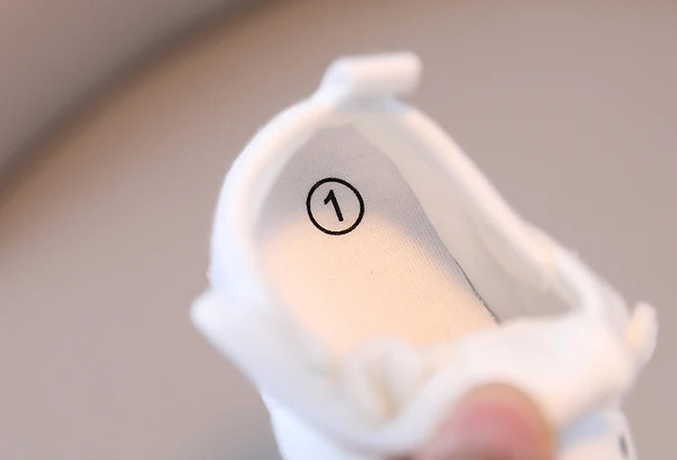 Close-up of a white plastic component with a circular mark on a gray background