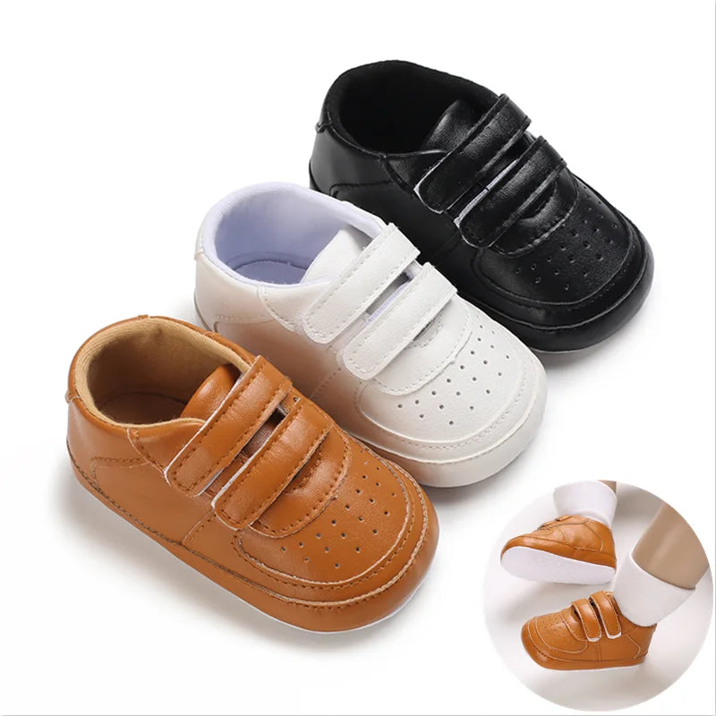 Three pairs of children's shoes in black, white, and brown on a white background.