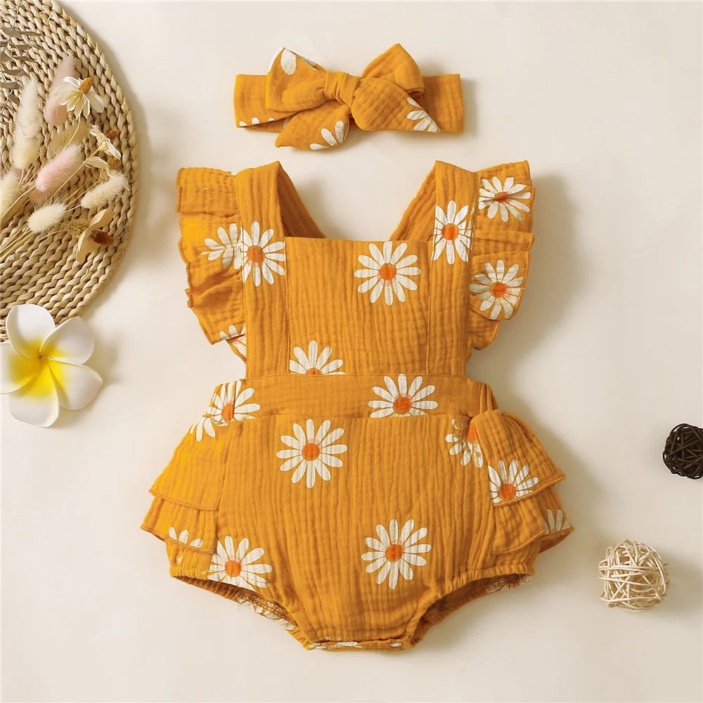 Yellow romper with white floral patterns and matching headband on a light background