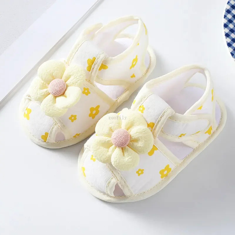 Pair of baby sandals with floral designs on a white background
