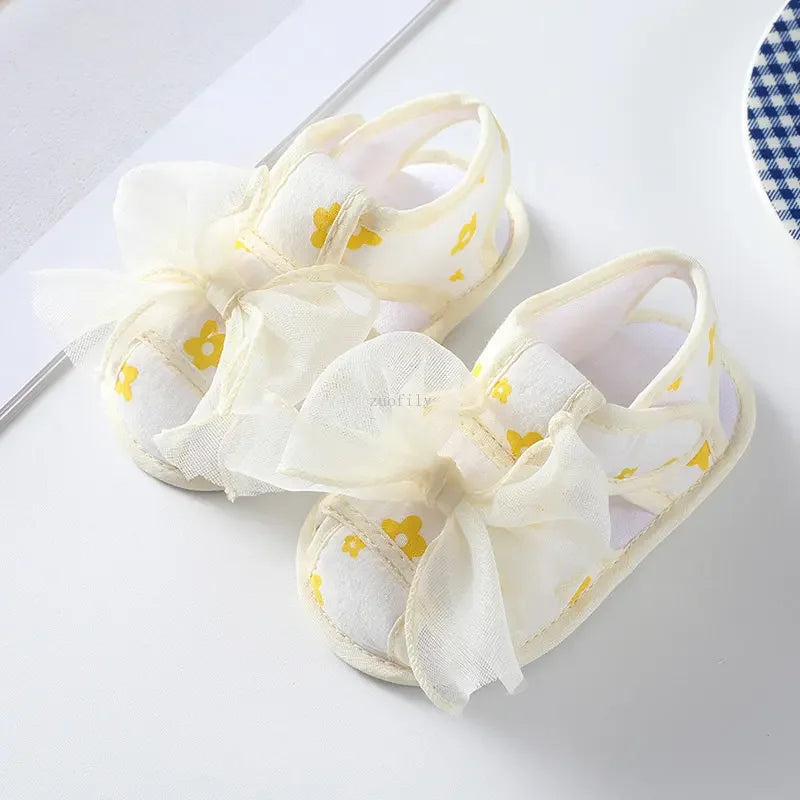 White sandals with yellow heart patterns on a white background