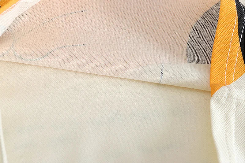 Close-up of a fabric with abstract patterns in beige, orange, and black.