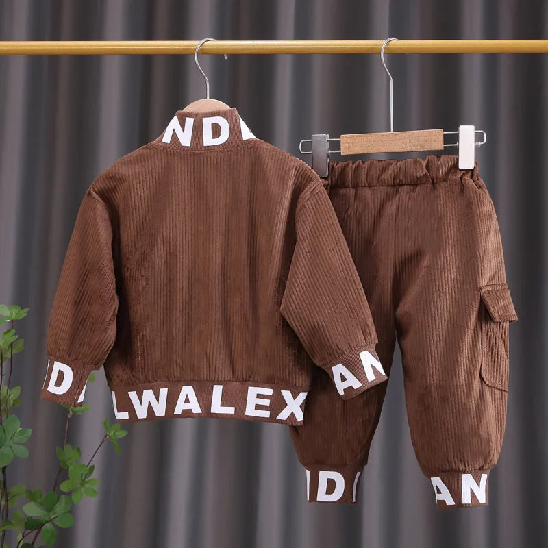 Brown corduroy children's outfit with 'DANWALEX' branding on a hanger against a gray curtain background.