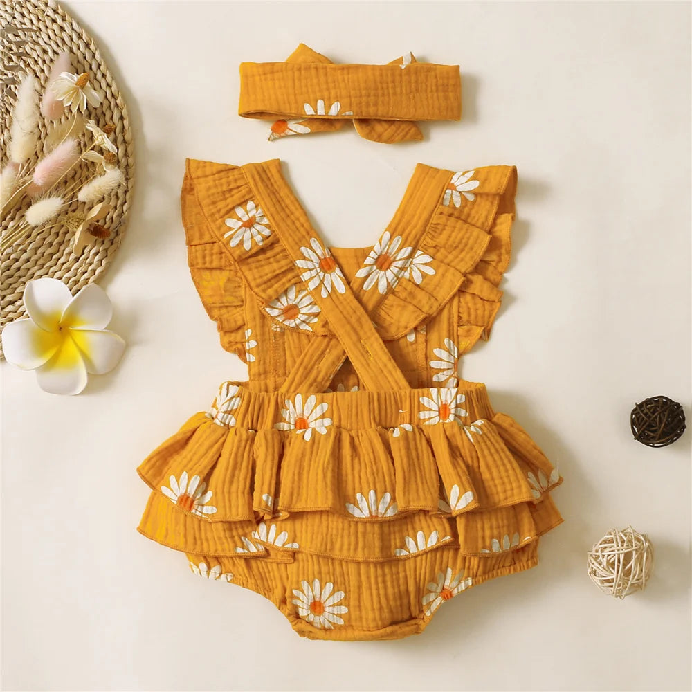 Yellow floral baby romper with matching headband on a light background