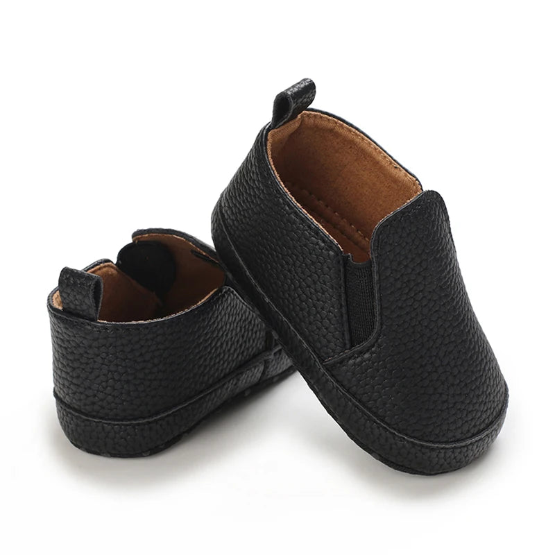 Pair of black textured shoes on a white background