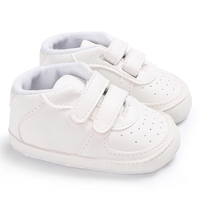 White baby shoes with velcro straps on a white background